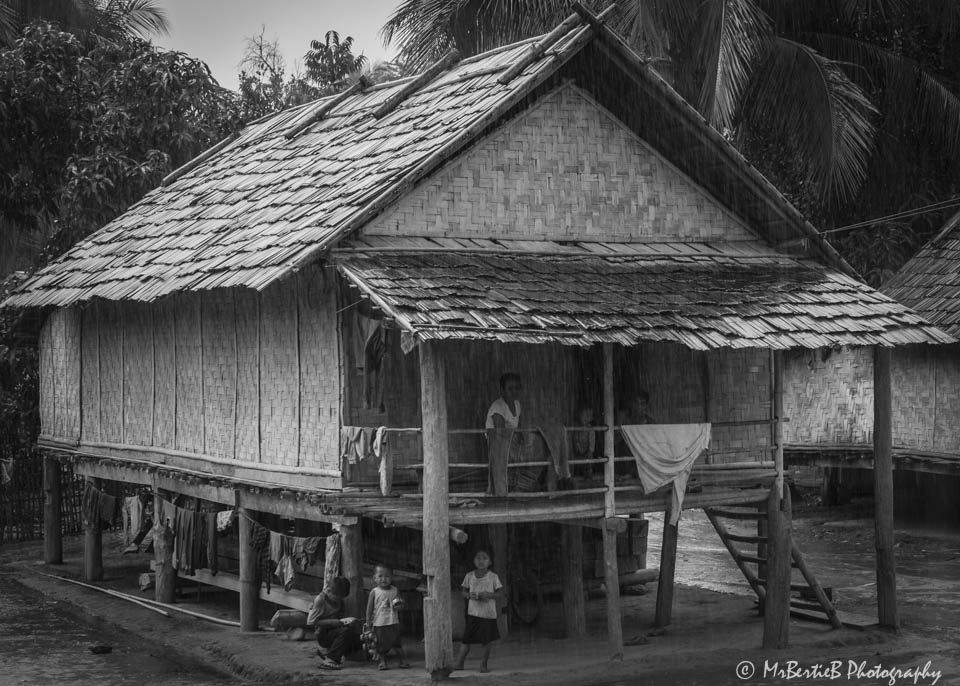 Villagers shelter from the rain in Northern Laos